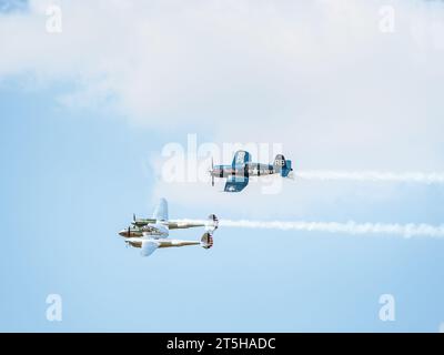 Bucarest, Roumanie - mai 2023 : les avions de guerre LOCKHEED P-38 LIGHTNING et chance Vought F4U Corsair font partie de la flotte Flying Bulls volant contre t Banque D'Images
