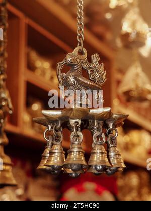 cloches de carillon de vent de paon accrochées à une chaîne, sculptées en bronze à l'intérieur d'un magasin de souvenirs pour dsiplay Banque D'Images