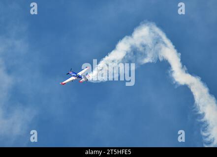 Skopje, Macédoine. L'avion acrobatique français Extra 330SC avec une traînée de fumée il a fait des miracles au-dessus de la tête des spectateurs. Banque D'Images