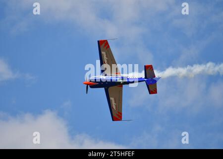 Skopje, Macédoine. L'avion acrobatique français Extra 330SC avec une traînée de fumée il a fait des miracles au-dessus de la tête des spectateurs. Banque D'Images