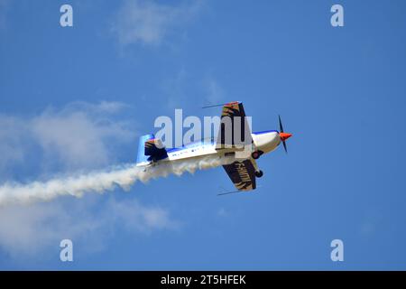 Skopje, Macédoine. L'avion acrobatique français Extra 330SC avec une traînée de fumée il a fait des miracles au-dessus de la tête des spectateurs. Banque D'Images