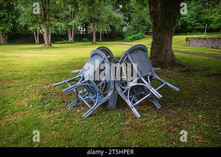 Quatre chaises sont regroupées autour d'une table sous un arbre dans un parc, St. Abbaye de Georges, Isny im Allgäu, Bade-Württemberg, Allemagne. Banque D'Images