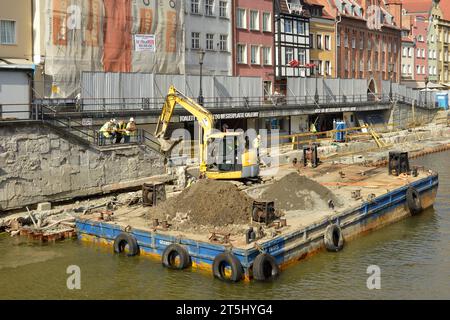 Travaux de rénovation et chantier avec excavatrice sur plate-forme flottante sur la promenade de la rivière Motlawa dans la vieille ville de Gdansk, Pologne, Europe UE Banque D'Images