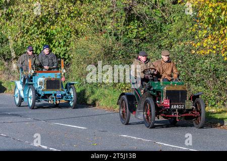 5 novembre 2023. Participants à la course de voitures vétérans de Londres à Brighton 2023 traversant le West Sussex, Angleterre, Royaume-Uni. Le parcours de l'événement annuel populaire s'étend sur 60 miles. Sur la photo : deux voitures sur la route, une Vulcan verte 1904 biplace et une Century bleue 1904 biplace Banque D'Images