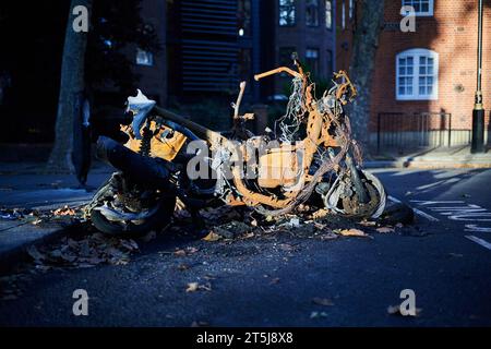 05 novembre 2023 - LondonUK : un cyclomoteur brûlé dans la rue de Londres une journée ensoleillée avec le soleil d'hiver Banque D'Images