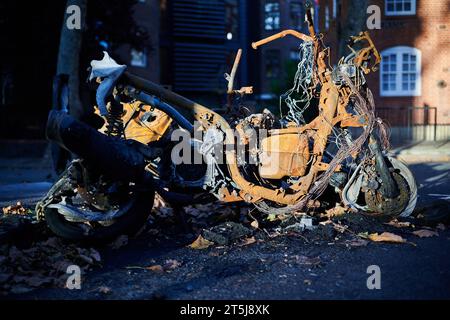 05 novembre 2023 - LondonUK : gros plan de cyclomoteur brûlé dans la rue de Londres une journée ensoleillée avec soleil d'hiver Banque D'Images