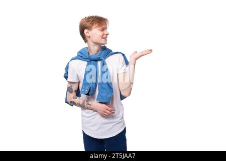jeune mec caucasien mignon avec les cheveux rouges courts avec un tatouage sur ses bras en gestation active Banque D'Images