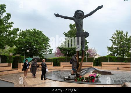 Personnes vénérant la statue du Christ ressuscité à Medjugorje. La statue désherit miraculeusement des gouttes de liquide du genou droit de Jésus. Banque D'Images