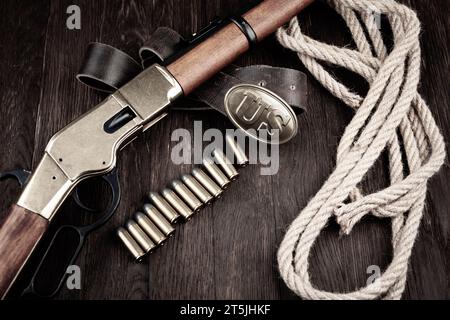 Fusil à répétition à levier avec cartouches et boucle en bronze de l'armée américaine marquée US sur une table en bois Banque D'Images