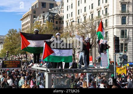 Washington, DC, États-Unis. 04 novembre 2023. Un groupe de manifestants pro-palestiniens hissent le drapeau palestinien alors qu’ils se tiennent debout au sommet d’un toit d’arrêt de bus à Washington, DC, samedi 4 novembre 2023. Des dizaines de milliers de militants pro-Gaza et pro-palestiniens ont défilé de Freedom Plaza à la Maison Blanche lors d’une manifestation « Marche nationale sur Washington : Palestine libre ». (Photo de Carlos Berrios Polanco/Sipa USA) crédit : SIPA USA/Alamy Live News Banque D'Images