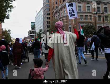 Washington, DC, États-Unis. 04 novembre 2023. Un homme marche avec sa fille lors de la “Marche nationale sur Washington : Palestine libre” à Washington, DC, samedi 4 novembre 2023. (Photo de Carlos Berrios Polanco/Sipa USA) crédit : SIPA USA/Alamy Live News Banque D'Images