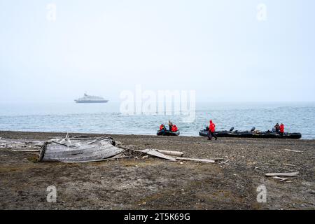 SVALBARD, NORVÈGE – 28 JUILLET 2023 : les touristes arctiques débarquent d'un navire de croisière sur la côte avec des bateaux pneumatiques rigides pour explorer les vestiges historiques de la chasse à la baleine Banque D'Images