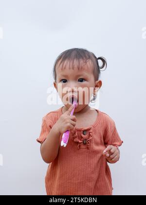 mignonne petite fille asiatique se brossant les dents Banque D'Images