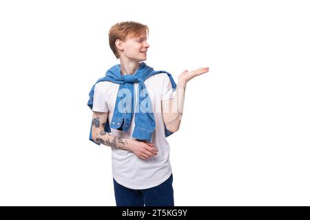 jeune mec caucasien mignon avec les cheveux rouges courts avec un tatouage sur ses bras en gestation active Banque D'Images