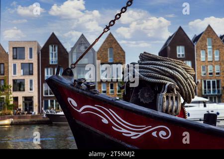 Rangée de maisons colorées sur les canaux de Haarlem avec une ancienne barge fluviale au premier plan Banque D'Images