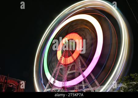 Photo de vitesse de shutterspeed lente de grande roue ou roue géante sur fond de ciel sombre pendant la nuit Banque D'Images