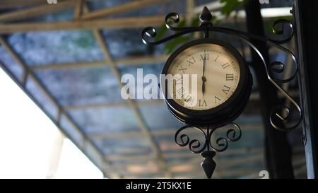 Horloge de rue vintage sur un poteau de fer tiré dans la vue d'angle de hing Banque D'Images