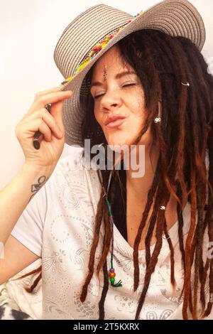 Femme bohème alternative avec des dreadlocks. Portrait ludique avec chapeau coloré Banque D'Images