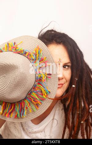 Femme bohème alternative avec des dreadlocks. Portrait ludique avec chapeau coloré Banque D'Images