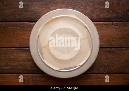 Vieille boîte de bobine de film de cinéma sur une planche en bois vintage rustique. Étiquette vierge avec espace de copie Banque D'Images