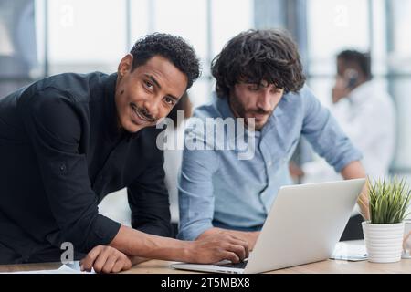 Professionnels d'affaires collaborant joyeusement dans un bureau moderne avec la technologie. Banque D'Images