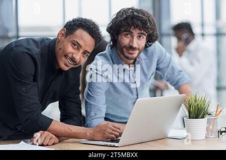 Professionnels d'affaires collaborant joyeusement dans un bureau moderne avec la technologie. Banque D'Images