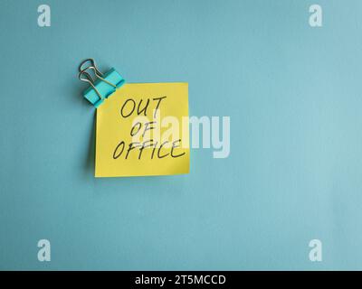 Absence du bureau, message sur papier jaune et fond bleu. Banque D'Images
