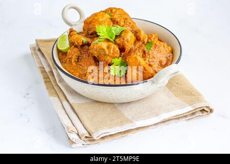 Curry de poulet indien à base de pâte de noix de cajou garnie de citron et de coriandre Banque D'Images