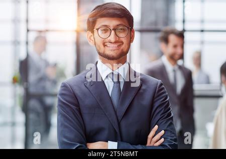 Beau jeune homme d'affaires debout confiant dans le bureau Banque D'Images