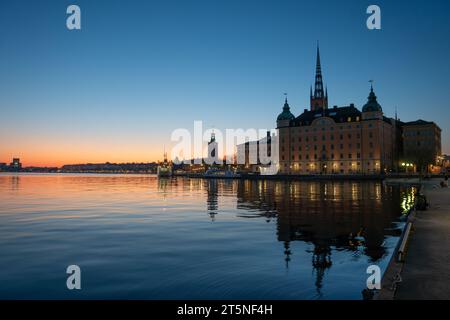 Crépuscule sur le lac dans le centre de Stockholm, avec la ligne d'horizon visible, l'hôtel de ville et des parties des vieux bâtiments de Riddarholmen. Espace de copie Banque D'Images