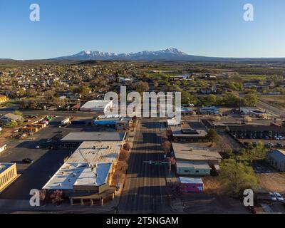 Vue panoramique de la petite ville rurale de Blanding, Utah au moment de la floraison printanière, ciel bleu et montagnes enneigées. Banque D'Images