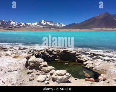 Homme dans une source chaude, Laguna Verde, Ojos del Salado, Andes, Chili. Ciel bleu profond, montagnes enneigées. Haute altitude et emplacement éloigné. Banque D'Images