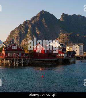 Village de pêcheurs de Henningsvaer, Lofoten, Norvège au coucher du soleil en été. Maisons rouges, montagne. Banque D'Images