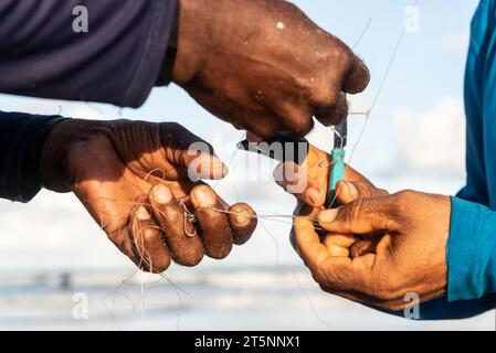 Salvador, Bahia, Brésil - 26 avril 2019 : mains de pêcheurs déliant la ligne de pêche. Pêche à la canne. Banque D'Images