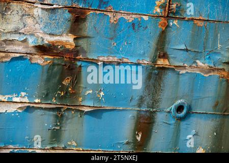 peinture peeling style shabby chic abstraite planqué sur une ancienne épave de navire ou coque de bateau de pêche. Banque D'Images