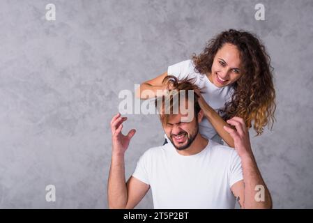 Femme courant les doigts à travers les cheveux d'homme Banque D'Images