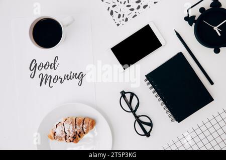 Tasse à café croissant avec papier message bonjour papeterie bureau bureau blanc Banque D'Images