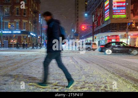 Toronto, Canada - 14 décembre 2013 : flou de mouvement d'une personne traversant une rue pendant une tempête de neige dans le quartier du centre-ville. Banque D'Images