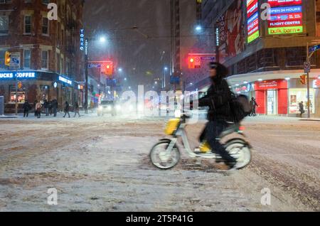 Toronto, Canada - 14 décembre 2013 : flou de mouvement d'une personne conduisant un vélo électrique pendant une tempête de neige. Banque D'Images