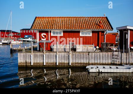 Hangars à bateaux rouge vif sur la côte ouest suédoise Banque D'Images