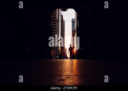 Silhouette personne marchant dans la lumière et le soleil éclat du tunnel de chemin sombre Banque D'Images