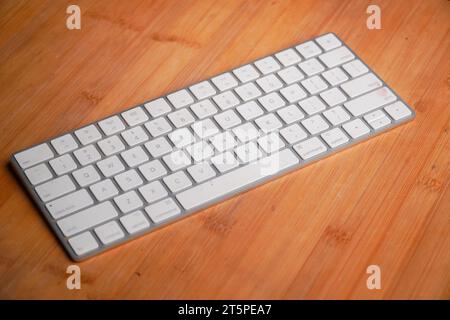 Petit clavier d'ordinateur blanc compact sur une table bambo. Design épuré minimaliste Banque D'Images