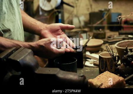 Homme travaillant dans un vieil atelier avec une faible lumière. Vieux nutsVintage lieu de travail en arrière-plan. Banque D'Images