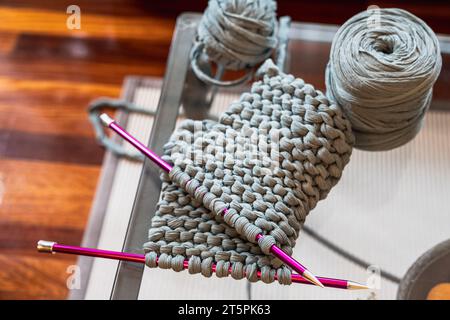 Gros plan des aiguilles et de la laine avec laquelle le pull est fabriqué Banque D'Images