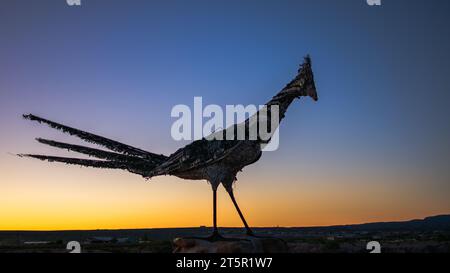 Une statue Roadrunner à Las Cruces, NM avec un coucher de soleil en arrière-plan. Banque D'Images