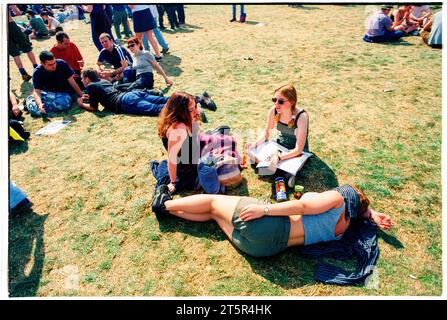 FANS DE BRITPOP et ROCK, READING FESTIVAL, 1998 : un groupe d'amis consulte le guide du programme du festival ensemble. Une scène du site et de la foule dans la zone main Stage Arena au Reading Festival 1998 le 28-30 août 1998 à Reading, Angleterre Royaume-Uni. Photo : Rob Watkins Banque D'Images