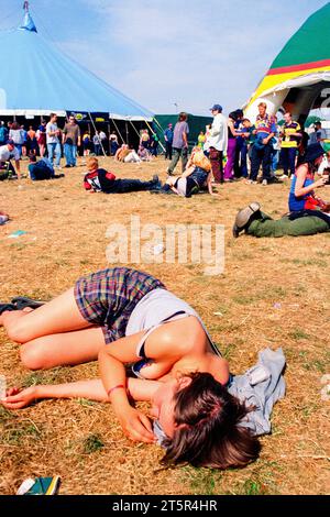 FANS DE BRITPOP et ROCK, READING FESTIVAL, 1998 : la chaleur extrême et les longues journées sont trop pour cette jeune femme qui s’écrase près de la Melody Maker Stage. Une scène du site et de la foule dans la zone main Stage Arena au Reading Festival 1998 le 28-30 août 1998 à Reading, Angleterre Royaume-Uni. Photo : Rob Watkins Banque D'Images