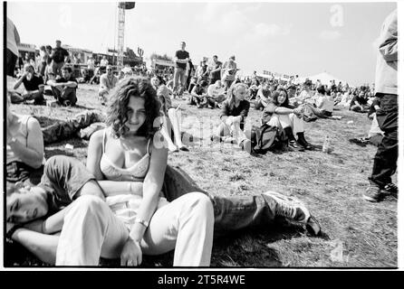 FANS DE BRITPOP et ROCK, READING FESTIVAL, 1998 : de jeunes amis partagent un moment de détente sur la scène principale. Une scène du site et de la foule dans la zone main Stage Arena au Reading Festival 1998 le 28-30 août 1998 à Reading, Angleterre Royaume-Uni. Photo : Rob Watkins Banque D'Images