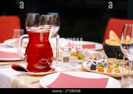 Carafe de jus de baies se tient sur une assiette sur une table de fête posée Banque D'Images