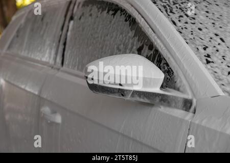 Auto recouvert de mousse de nettoyage au lavage de voiture extérieur, closeup Banque D'Images